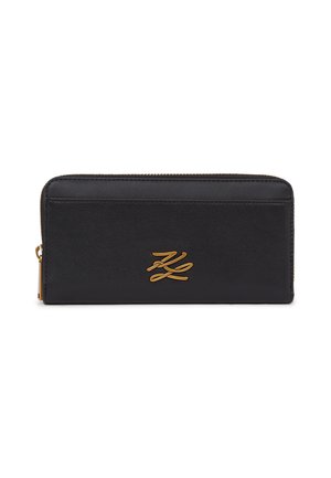 Cartera negra rectangular con cremallera que rodea, con un emblema de logotipo dorado centrado en el panel frontal.