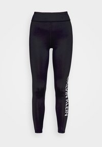 Černé legíny vyrobené z elastického materiálu, s vysokým pasem a bílým logem "Calvin Klein" na levé straně. Hladká textura.
