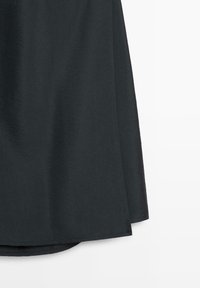 Schwarzer Rock mit glatter, leicht glänzender Textur. Verfügt über einen abgerundeten Saum und ein klares, schlichtes Design ohne Muster oder Verzierungen.