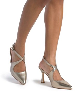 Metallic gold high-heeled shoes with a pointed toe, cut-out sides, and an ankle strap adorned with a decorative accent.