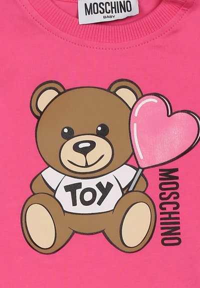 Camicia di cotone rosa con un orsetto di cartone che tiene un palloncino a forma di cuore, indossando una maglietta con la scritta "TOY," con il nome del marchio Moschino.