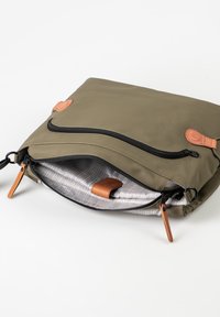 Borsa verde oliva, resistente all'acqua, con cerniera nera; dettagli in pelle color cuoio; interno foderato con motivo a griglia; design a bustina, aperta.