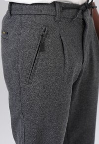 Gray trouser with a textured fabric, featuring a zipped pocket and a drawstring waistband for adjustable fit.