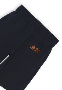 Pantaloni corti blu navy con cintura elasticizzata, dotati di una singola tasca sul retro con ricamo geometrico arancione e una texture liscia.