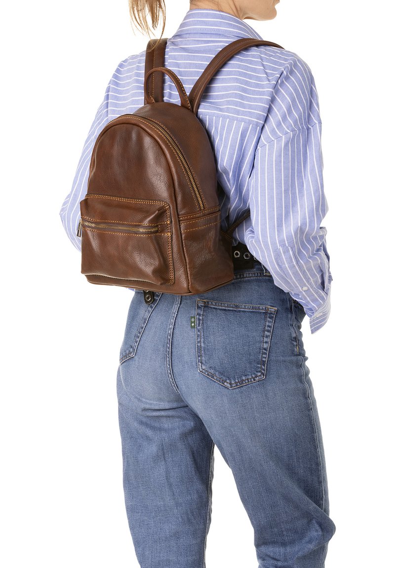 Sac à dos en cuir marron avec une forme arrondie, doté d'une poche zippée à l'avant, de deux bretelles et d'une surface texturée.