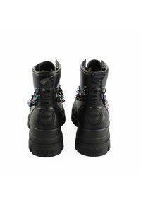 Black ankle boots with textured leather, featuring colorful chain accents and logo on the heel. Thick rubber soles for durability.