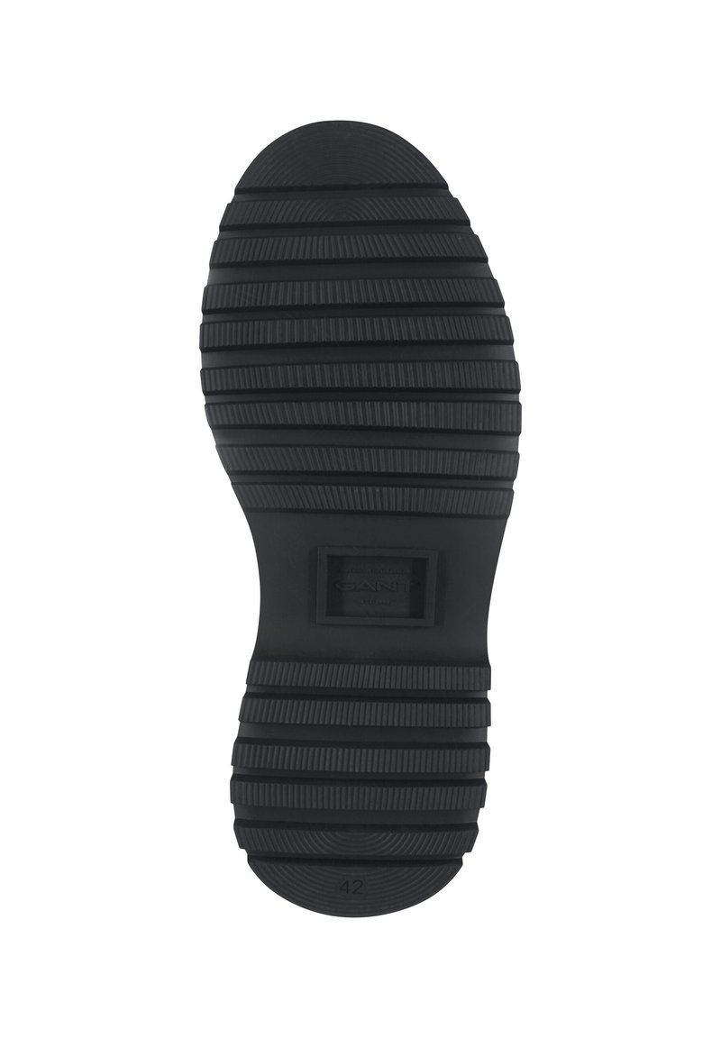 Czarna gumowa podeszwa buta z głębokimi poziomymi rowkami, prostokątny obszar z logo marki na środku oraz numer rozmiaru 42 w pobliżu pięty.