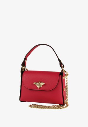 Sac à main en cuir rouge avec un emblème d'abeille doré sur le rabat, équipé d'une bandoulière en chaîne et de détails noirs. Forme rectangulaire compacte.