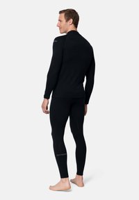 Conjunto de capa base térmica negra, que incluye una camiseta de manga larga y leggings ajustados. Textura suave y con detalles de costura mínimos, diseñado para proporcionar calidez.