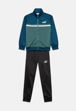 Dres z turkusowo-zieloną kurtką na zamek z białym paskiem, zestawiony z czarnymi spodniami, oba z białym logo Puma.