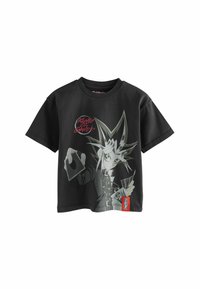 Sort bomulds T-shirt med en grafisk print af en karakter med spidse hår og kort, mærket "KING OF GAMES." Korte ærmer, afslappet pasform.