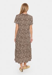 Leopardmönstrad, kortärmad maxiklänning med lagerdesign. Har rund halsringning och mjukt, flödande tyg. Bärs med platta espadrillos.