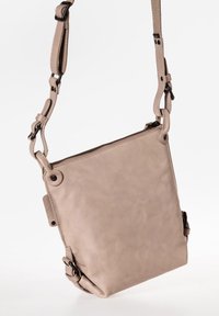 Borsa a tracolla in pelle beige con forma rettangolare, chiusura a zip, tracolla regolabile e lievi variazioni testurali sulla superficie.