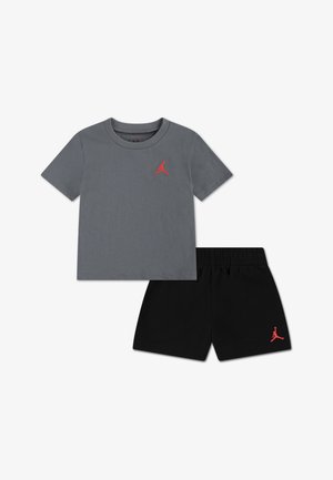 Szürke pamut póló piros Jumpman logóval a mellkason, fekete rövidnadrág fekete ugyanazzal a logóval. Rugalmas derékrész a rövidnadrágon.