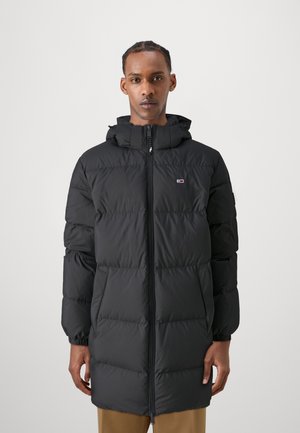 Black puffer coat with a zip closure, hood, and side pockets. Features a quilted design and elastic cuffs for snug fit. Lightweight material.