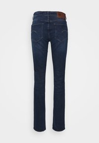 Mörkblå denimjeans med rak benmodell, med en läderetikett i midjan och två bakfickor med subtila sömdetaljer.