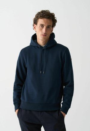 Marineblaues Hoodie mit einer Kordelzugkapuze, gerippten Bündchen und Saum. Verfügt über ein Logo-Patch an der linken Ärmels und hat eine glatte Textur.