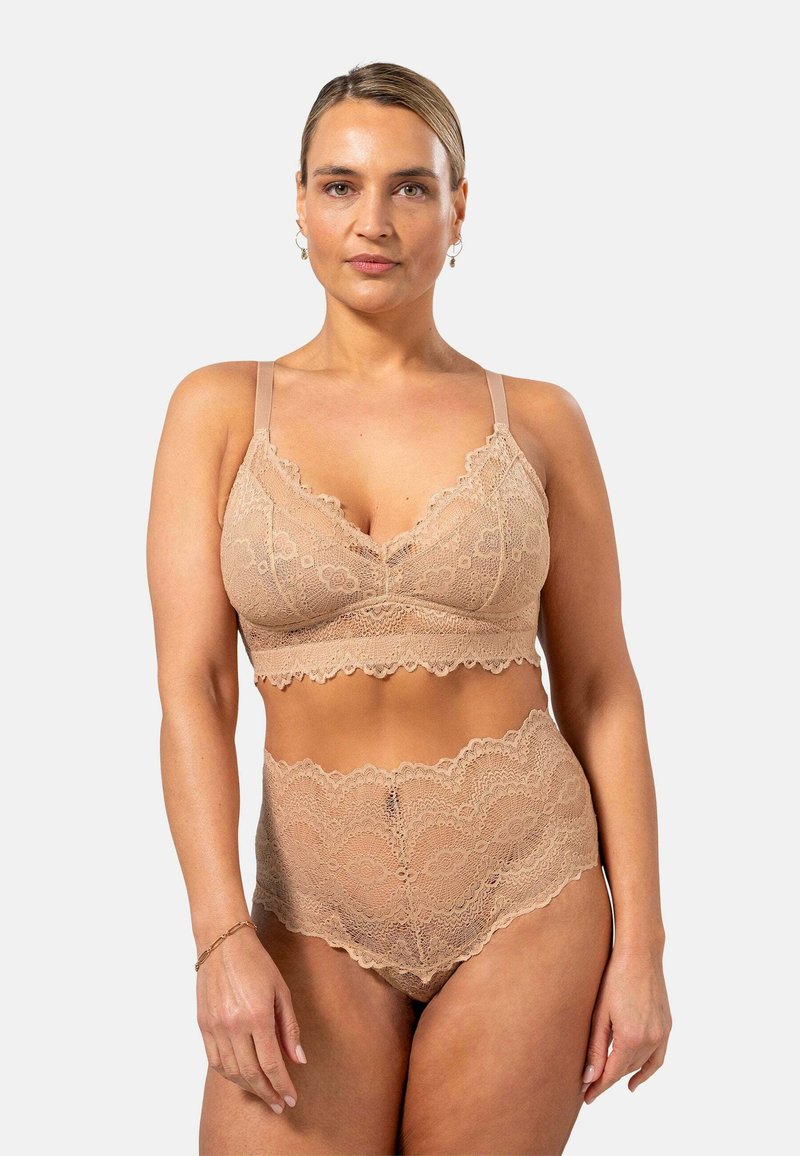 Verkkopitsinen bralette ja vyötäröltä korkeammat alushousut nude-värissä, joissa on aaltoilevat reunat ja kukkakuviot. Pehmeä, teksturoitu kangas, jossa on säädettävät hihnat.