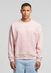 Felpa rosa con scollo a girocollo, tasca frontale e testo bianco "ANOTHER COTTON". Maniche lunghe con polsini e orlo a costine. Tessuto morbido.