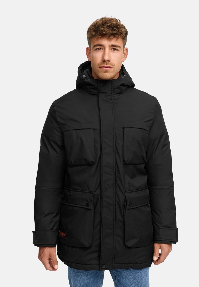 Parka nera isolata con cappuccio, chiusura anteriore a snap, due grandi tasche con patta e polsini regolabili. Tessuto testurizzato e accento con logo arancione.