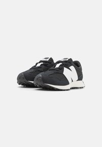 Baskets noires et blanches avec une tige en maille, des panneaux texturés, une semelle rembourrée et un design à lacets, arborant le logo New Balance.