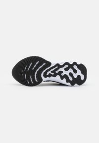 Suela de zapato con forma curva que presenta una mezcla de goma negra y blanca. Patrón ondulado único con surcos texturizados para tracción.