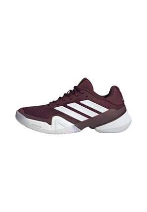 Zapatilla deportiva burdeos con suela blanca y tres rayas blancas en el lateral, diseñada para el rendimiento deportivo.