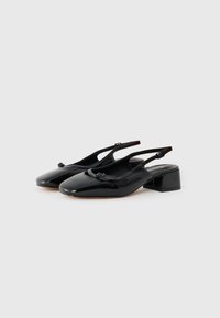 Scarpe slingback in vernice nera con tacco quadrato basso, caratterizzate da un fiocco decorativo sulla parte anteriore e una punta arrotondata.