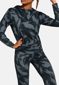 Sportowa bluza z kapturem w ciemnoszarym kolorze, ozdobiona wzorem liści w jaśniejszym odcieniu szarości. Gładka faktura, dopasowany krój, z boczną kieszenią na zamek.