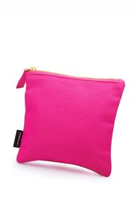 Rosa tygpåse med en gyllene dragkedja, fyrkantig form, robust textur och en liten etikett på ena sidan som säger "YOKOAMI."