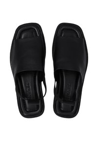 Schwarze Leder-Sandalen mit breitem Riemen über dem Fuß, flacher Sohle und minimalistisches Design. Strukturierte Kanten und dezentes Branding-Detail.