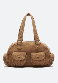 Sac à main en velours côtelé marron de forme arrondie, avec deux poignées, deux poches avant et une fermeture éclair. Tissu texturé avec des accents en laiton.