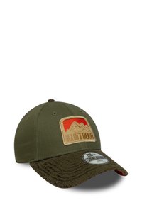 Adjustable cap made of olive green fabric with a textured dark green brim. Features a mountain patch with red and beige accents.