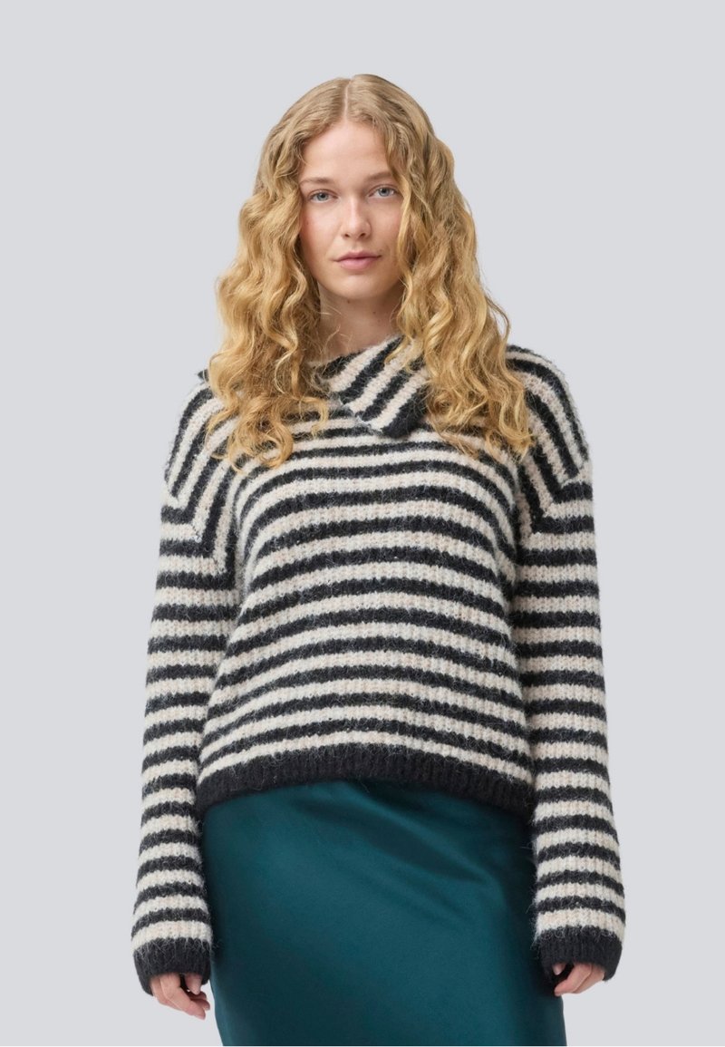 Maglione a righe realizzato in filato morbido e soffice, nei colori crema e blu navy. Presenta un ampio scollo e maniche lunghe, con una vestibilità rilassata e orlo a coste.