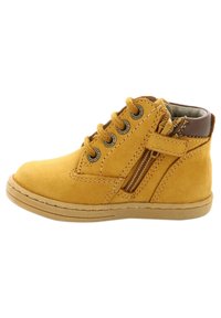 Stivale alla caviglia in suede giallo con otto occhielli, dettaglio marrone sul collo, zip laterale e suola in gomma. Presenta dettagli di cucitura e finitura testurizzata.
