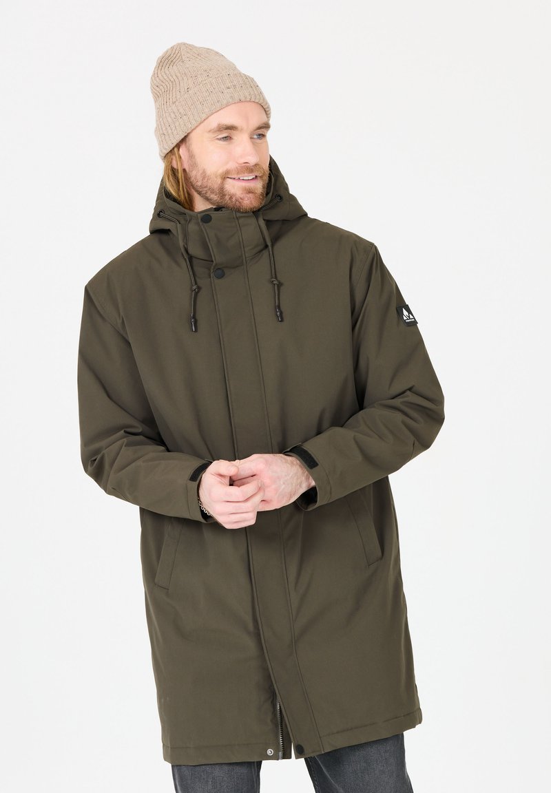 Parka verde oliva con cappuccio, dotata di chiusura con zip e bottoni a pressione, cordoncini regolabili, due tasche frontali e polsini a coste.