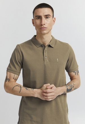 Oliven grøn polo shirt med krave og korte ærmer, der har en tre-knaps placket og broderet logo på brystet.
