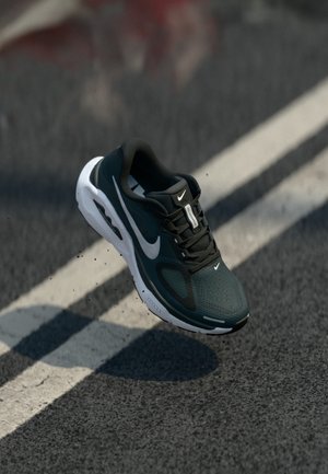 Melni un tirkīza sporta apavi ar fakturētu augšdaļu, baltu zoli un redzamu Nike logotipu. Mežģīnes un polsterējums ērtībai.