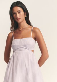 Hele lilla kleit vertikaalsete valgete triipudega, istuva lõikega bodi, õhukeste rihmade ja voolava seelikuga. Küljel lõigatud detailid.