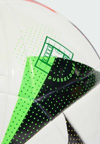 Ballon de soccer blanc avec des motifs géométriques verts et noirs, arborant un logo de Düsseldorf et des accents en pointillés dans diverses nuances de vert.