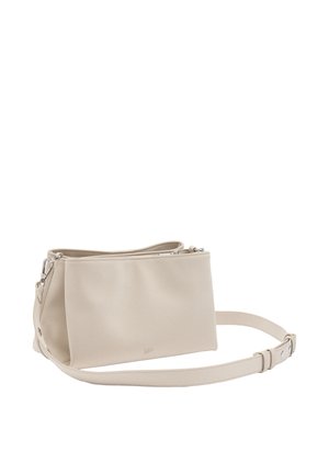 Beżowa torba na ramię wykonana z gładkiego materiału, o zaokrąglonym kształcie, z górnym zamkiem błyskawicznym i regulowanym paskiem. Prosty design z minimalistycznymi akcentami.