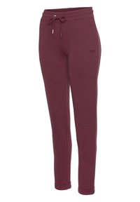Bordeauxfarbene Sweatpants aus weichem Material, mit einem elastischen Bund und Zugband sowie gerippten Bündchen. Dezentes Logo an der Seite.
