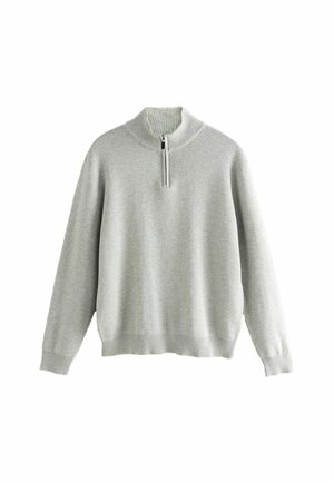 Sweater long beige clair à manches longues avec un col montant côtelé et une fermeture à zip sur le quart, présentant des poignets et un ourlet côtelés.