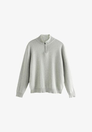 Sweater long beige clair à manches longues avec un col montant côtelé et une fermeture à zip sur le quart, présentant des poignets et un ourlet côtelés.