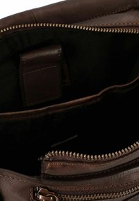 Bruine leren tas met een binnenkant met een ritssluiting vak. Heeft een donkere stoffen voering en een klein vakje voor kaarten of spullen. Rits hardware zichtbaar.