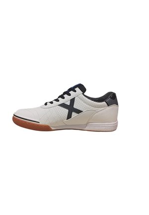 Zapatilla blanca con acentos negros, que presenta un diseño acolchado, lengüeta de malla y suela de goma. Incluye un prominente logotipo negro en forma de X.