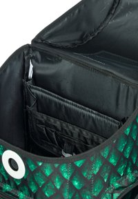 Wnętrze torby w czarno-zielony wzór ma wiele przegród, gładką teksturę oraz okrąły akcent z metalu.