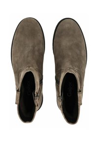 Bottines en daim marron avec fermetures éclairs latérales, bouts ronds et semelles noires contrastantes. L'intérieur présente le nom de la marque "Gabor" en impression subtile.