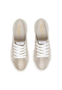 Beige lerretsneakers med hvite lisser, strukturert overdel og lett hvit såle. Har en logo-patch på tungespissen.