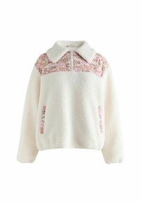 Pulover din fleece crem cu yoke, guler și fermoar cu model floral roz. Dispune de două buzunare laterale cu accente florale.